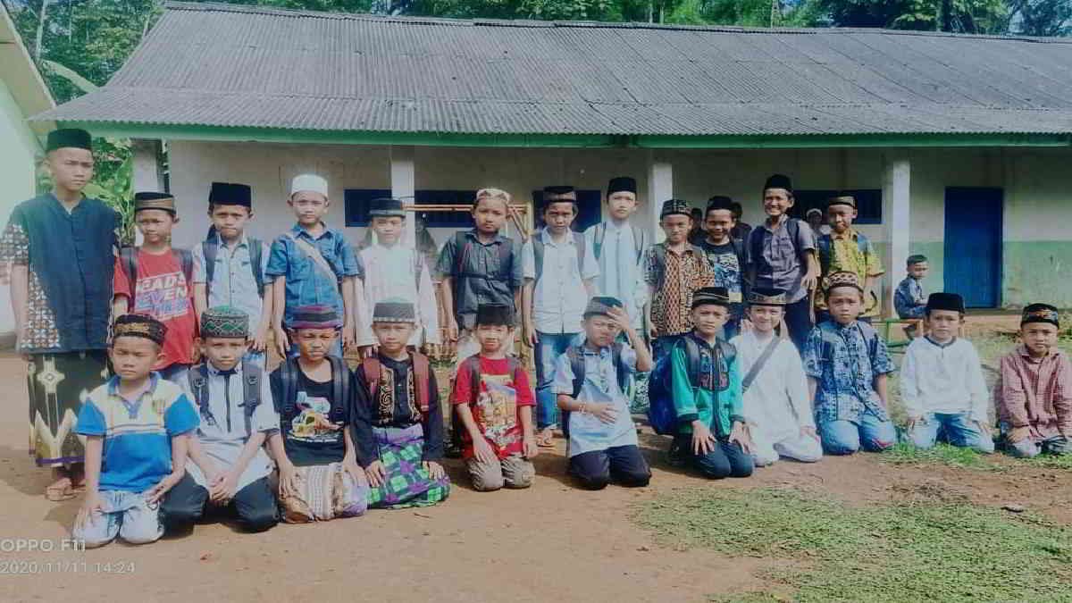 Peserta didik perdana Madrasah Asbabul U'lum, Desa Gunung Sugih Besar, sumringah foto bersama dengan latar belakang gedung sekolah yang memprihatinkan, karena Belum pernah ada perbaikan selama puluhan tahun, Kamis (12/11/2020) - foto Dok