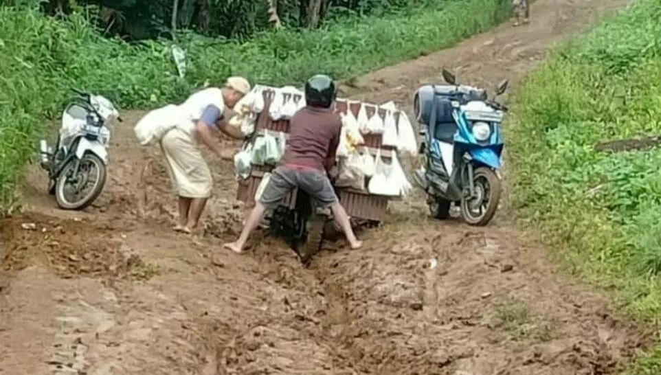 Memprihatinkan, puluhan tahun jalan lingkar Kabupaten di Dusun Sukabaru Pekon Tanjung Jati menuju Pekon Kampung Baru Kecamatan Kotaagung Timur, Tanggamus tak tersentuh perbaikan. Terlihat warga sedang berusaha keras melintasi jalur tersebut, Selasa (28/12/2021)- foto Sumantri
