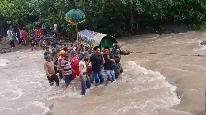 warga penyandingan harus menyebrangi sungai berarus deras menggotong keranda jenazah untuk menuju pemakaman di wilayah set empat, Jumat (17/12/2021) - foto ist