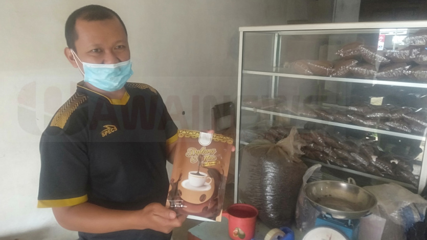 Budi Sasmito, Penggiling Kopi Bubuk Robusta saat ditemui di kiosnya. Minggu (30/1/22), foto- Sumantri