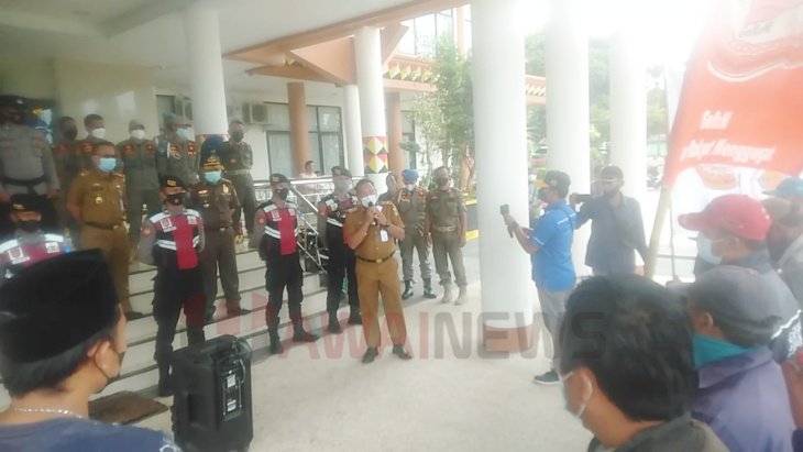 Puluhan massa dikawal petugas berdemo di depan kantor Bupati Tanggamus, Selasa (1/3/22).