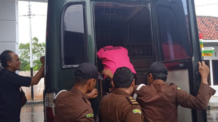 Kepala kampung (Kakam) Rekso Binangun, Rumbia, Lampung Tengah Indra Wardana akhirnya mengenakan rompi orange dan digiring ke jeruji besi menaiki mobil tahanan, Rabu (19/10/2022).