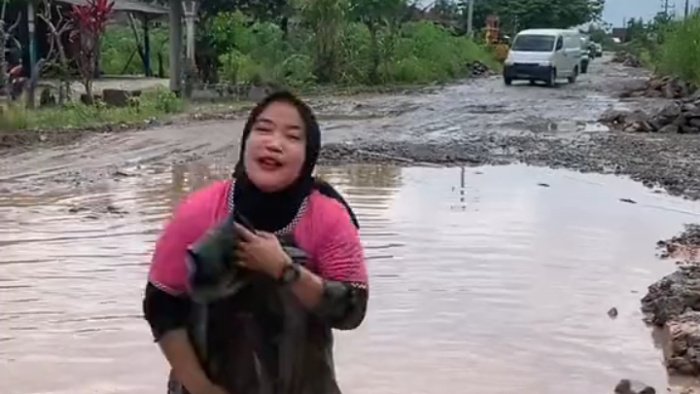 Tiktoker Mita Desiana dengan logat kental Lampung sambil aksi mandi dengan tangan seolah-olah berenang di kubangan, (foto_scn ttk)