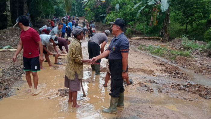 Warga Pekon Tanjungan Kecamatan Pematang Sawa membersihkan jalan dari timbunan material longsor, pada Jum'at 7 Juli 2023.