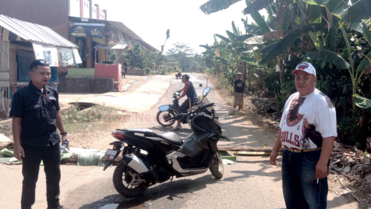 Foto: Rohman (topi) sedang mengalihkan pengendara yang melintas di jalan lintas pekon Siderejo, Sumberejo karena sedang ada perbaikan jalan secara swadaya oleh masyarakat setempat, Jumat 26 Juli 2024.