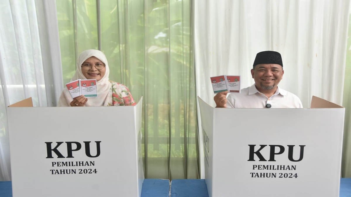 Heri Koswara saat memberikan hak suara lengkap dengan keluarga istrinya, Nur Indah Harahap dan putra-putrinya Bassam dan Basiimah memberikan hak suara di TPS 019 Jatiluhur, Jatisasih, Rabu 27 November 2024