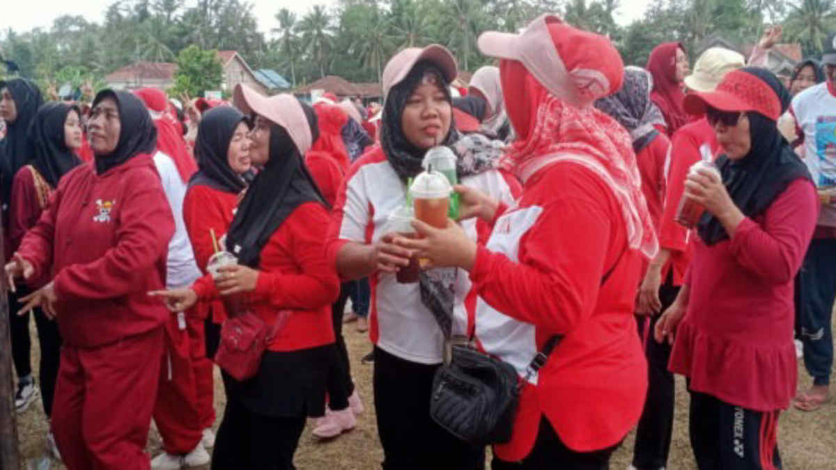salah seorang pedangan es cup membagikan jualannya secara gratis untuk peserta kampanye terbuka Paslon Dawam-Erawan (DAI) di Lapangan Sepakbola, Desa Adirejo, Kecamatan Jabung, Lampung Timur, Senin 4 November 2024.