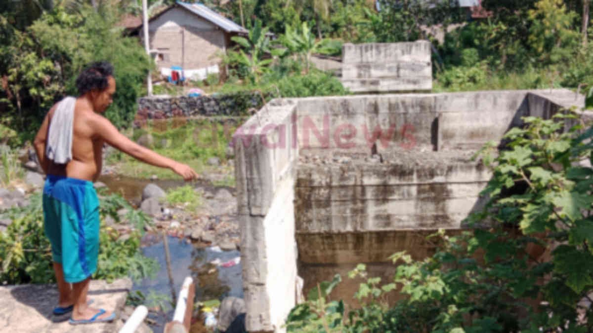 Foto: Warga Dusun Madang Atas, Pekon Kusa saat menunjukan pondasi penyangga jembatan yang dibangun akhir tahun 2023 lalu yang saat ini mangkrak dan menjadi tempat pembuangan sampah, Jumat 27 Desember 2024, - sm