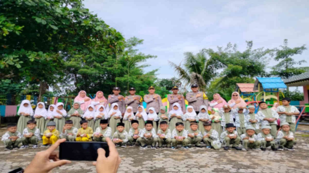 Kapolsek Sekampung Udik AKP Rihamuddin menyapa dan Bagikan Bubur dan susu di TK Al Azhar 3, di Desa Gunung Pasir Jaya, Lampung Timur, Rabu 8 Januari 2025 - foto Jali