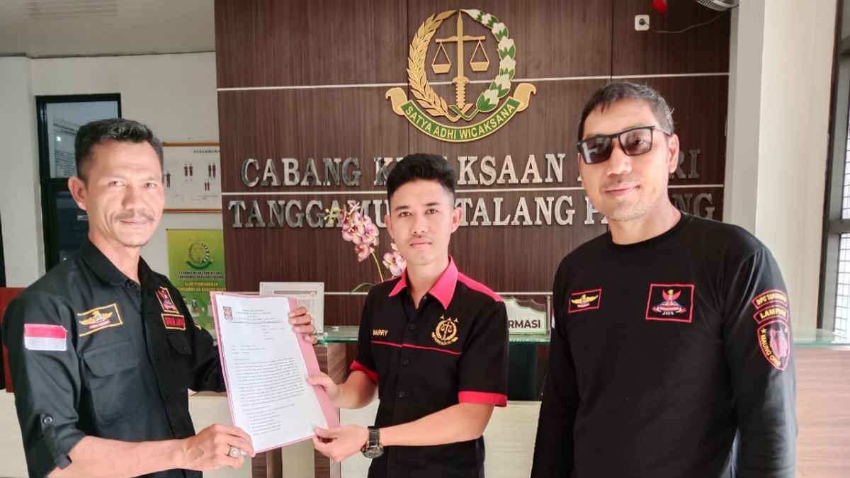 Foto Ketua Grib Jaya PAC Pugung menyerahkan surat laporan kepada peyugas PTSP Cabjari Tanggamus di Talang Padang, pada Kamis 13 Februari 2025, (foto_ws).